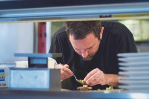 Chef adding finishing touch to meal