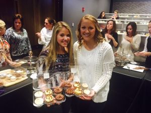Two friends showing off cupcakes that they made