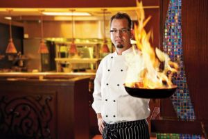 Man holding a pan that is on fire